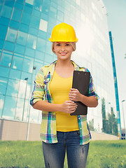 Image showing smiling woman in helmet with clipboard