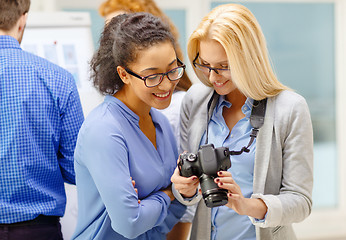 Image showing two women looking at digital camera at office