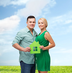 Image showing smiling couple holding green paper house