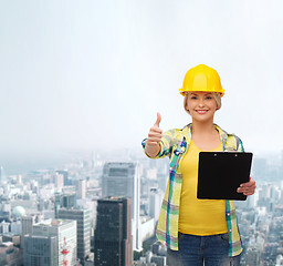 Image showing smiling woman in helmet with clipboard