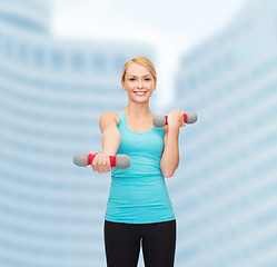 Image showing young sporty woman with light dumbbells