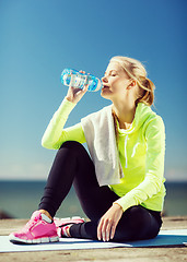 Image showing woman drinking water after doing sports outdoors