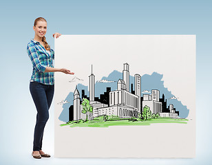 Image showing smiling young woman with board and city drawing