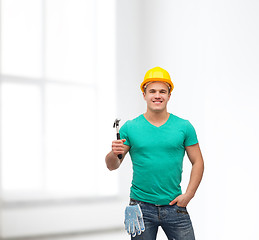 Image showing smiling manual worker in helmet with hammer