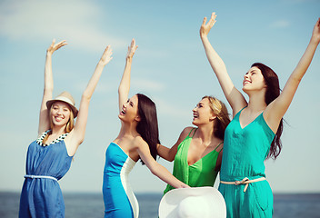 Image showing girls looking at the sea with hands up