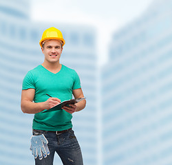 Image showing smiling man in helmet with clipboard