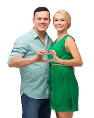 Image showing smiling couple showing heart with hands