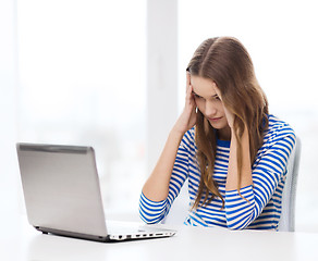 Image showing upset teenage gitl with laptop computer at home