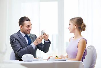 Image showing smiling man taking picture with digital camera