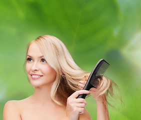 Image showing smiling woman with hair brush