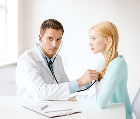 Image showing doctor with stethoscope listening to the patient