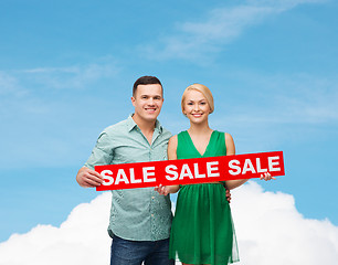 Image showing smiling couple with sale sign