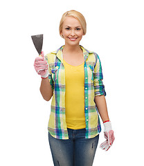Image showing smiling female worker in gloves with spatula