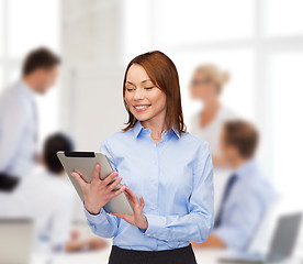 Image showing smiling woman looking at tablet pc at office