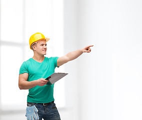 Image showing smiling man in helmet with clipboard