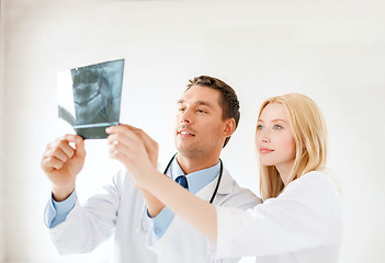 Image showing smiling male doctor or dentist looking at x-ray