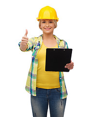 Image showing smiling woman in helmet with clipboard