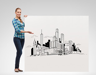 Image showing smiling young woman with board and city drawing