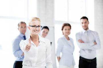 Image showing businesswoman in office showign thumbs up