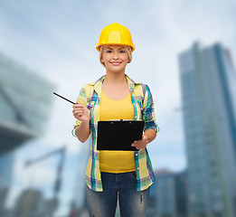 Image showing smiling woman in helmet with clipboard