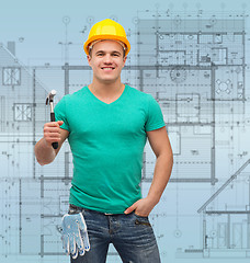 Image showing smiling manual worker in helmet with hammer