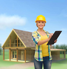 Image showing smiling woman in helmet with clipboard