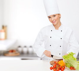 Image showing smiling female chef chopping vagetables