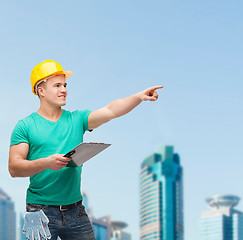 Image showing smiling man in helmet with clipboard