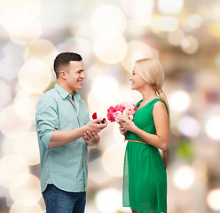 Image showing smiling couple with flower bouquet and ring