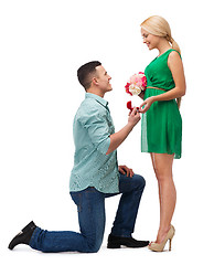 Image showing smiling couple with flower bouquet and ring