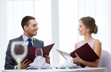 Image showing smiling couple with menus at restaurant