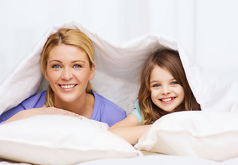 Image showing mother and little girl under blanket at home