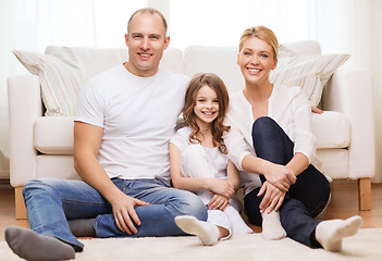 Image showing parents and little girl sitting on floor at home