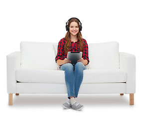 Image showing girl sitting on sofa with headphones and tablet pc