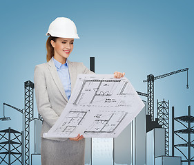 Image showing smiling architect in white helmet with blueprints