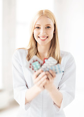 Image showing young female doctor with pack of pills