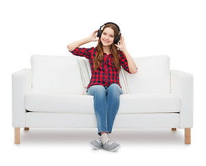 Image showing teenage girl sitting on sofa with headphones