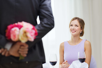 Image showing young woman looking at man with flower bouquet