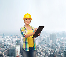 Image showing smiling woman in helmet with clipboard