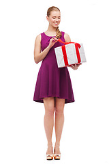Image showing wondering smiling girl with present box
