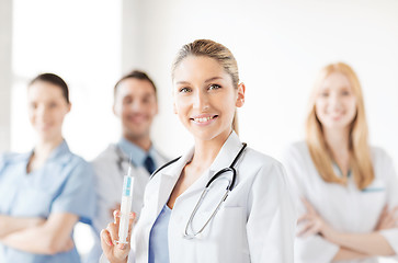 Image showing female doctor holding syringe with injection