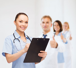 Image showing smiling female doctor or nurse with stethoscope