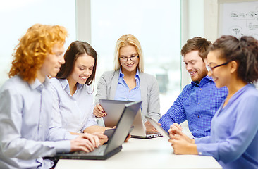 Image showing smiling team with laptop and table pc computers