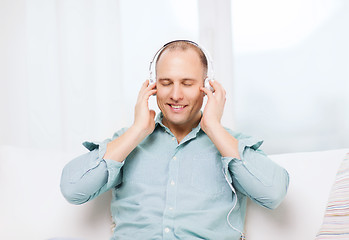 Image showing smiling man with headphones listening to music