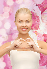 Image showing smiling woman showing heart shape gesture
