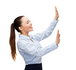 Image showing smiling businesswoman pointing to something