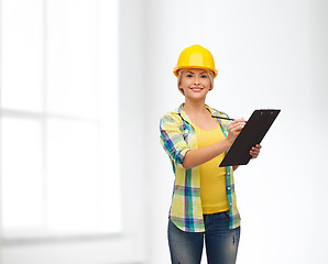 Image showing smiling woman in helmet with clipboard