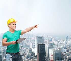 Image showing smiling man in helmet with clipboard