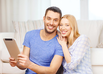 Image showing smiling happy couple with tablet pc at home