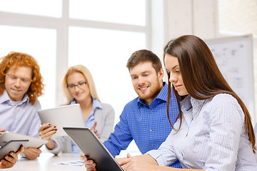 Image showing smiling team with table pc and papers working